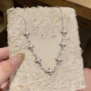 Detailed view of silver-tone cross necklace with elegant pearls and crystal accents