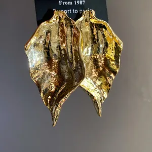 Detailaufnahme von Vintage-Ohrringen in goldener Blattform mit strukturierter Oberfläche