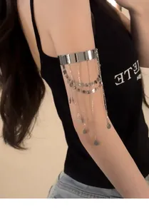 Dettaglio del bracciale da braccio in argento con paillettes e nappe indossato dal modello