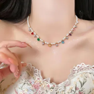 Close-up of elegant pearl necklace with vibrant glass teardrop charms on Asian model