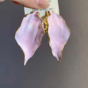 Detailansicht von rosa Blattohrringen mit Goldrand auf einer OBN JEWELRY Karte