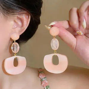 Detailed shot of sweet pink resin oval drop earrings with silver needle posts