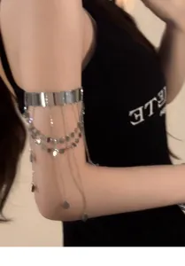 Dettaglio di un bracciale da braccio argento con paillettes rotonde e catenine