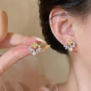 Detailed shot of elegant butterfly diamond stud earrings with yellow zircon and pearl