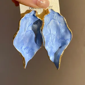 Detailansicht der vintage blauen Blatt-Ohrstecker mit goldfarbenem Rand auf Karte.
