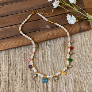 Elegant pearl necklace with colorful glass pendants on a rustic wooden background
