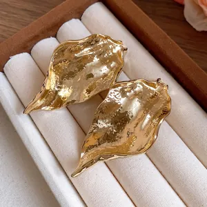 Detailaufnahme goldener Vintage-Ohrstecker in Blattform mit strukturierter Oberfläche