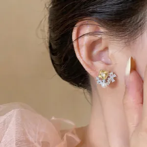 Elegant butterfly zircon stud earring with square yellow zircon and pearl on model