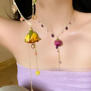 Close-up detail of a dainty rose pendant necklace with colorful crystal beads on an Asian model