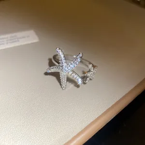 Close-up of a shimmering silver starfish open ring featuring delicate micro-paved crystals