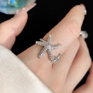 Close-up detail view of a shimmering silver starfish open ring with micro-pave cubic zirconia