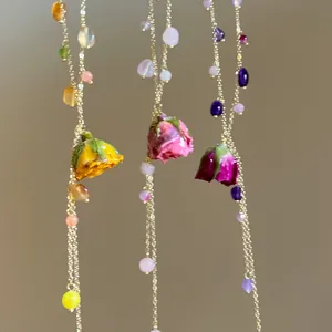 Close-up of handmade necklaces with real dried rose buds and colorful beads.