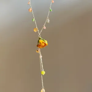 Dainty necklace featuring a dried yellow rose bud and multi-colored translucent crystal beads