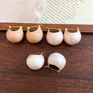 Close-up view showing gold-plated bean hoop earrings in pearl white, pink, and beige finishes