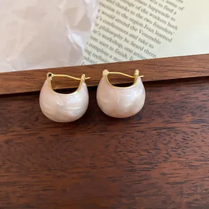 Close-up of elegant retro Korean gold plated bean hoop earrings with pink enamel finish