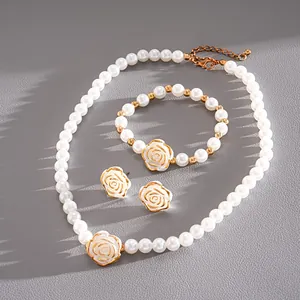 Detailed macro shot of vintage white camellia flower and faux pearl jewelry set