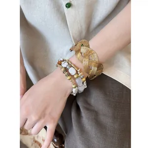 Detailed macro shot of vintage Maillard style woven resin bangle and beaded bracelet stack