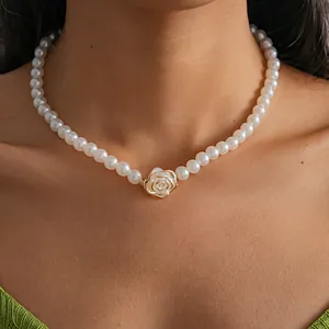 Close-up detail of a vintage white camellia flower pendant on an elegant pearl necklace