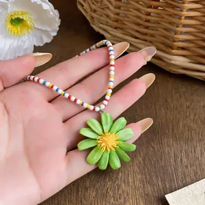 Dettaglio di una collana di perline colorate con un ciondolo a forma di margherita