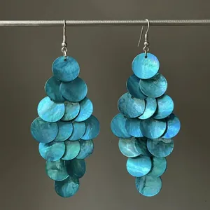 Close-up of blue iridescent shell disc earrings in a tiered dangling design