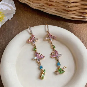 Colorful butterfly zircon tassel drop earrings in dopamine style on a white plate