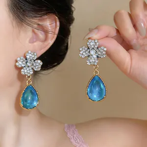 Dettaglio degli orecchini a fiore vintage con resina blu e accenti di cristallo