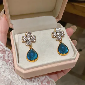 Dettaglio degli orecchini in stile vintage con pendenti a goccia d'acqua blu intenso