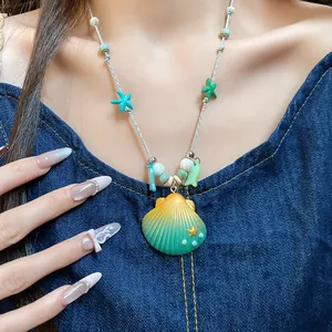 Primer plano de un collar estilo playa con colgante de caracola y estrellas de mar.