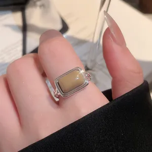 Nahaufnahme eines Vintage-Rings mit rechteckigem Katzenaugenstein und gedrehtem Silberband.