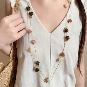 Double-layered necklace with Maillard-style acrylic square beads on a beige vest