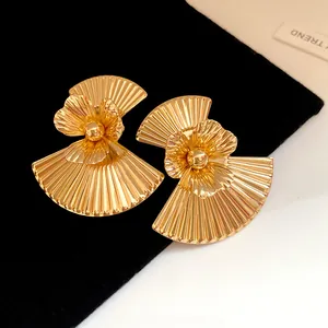 Detailed view of vintage gold fan-shaped metal earrings with central flower design