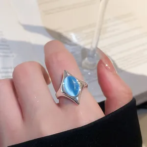 Makroansicht eines silbernen geometrischen Rings mit blauem Katzenaugenstein