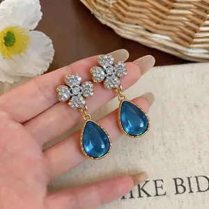 Orecchini vintage dorati con fiori di cristallo e pendenti a goccia in resina blu