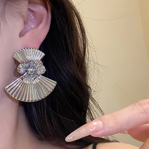 Close-up of vintage pleated silver fan earrings with center flower on model's ear