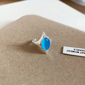 Detail eines silbernen Rings mit einem leuchtend blauen ovalen Katzenaugenstein