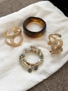Exquisite collection of vintage style resin bangles and gold metal cuffs on linen