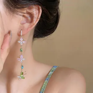 Elegant colorful zirconia butterfly long tassel earrings worn by a model closeup