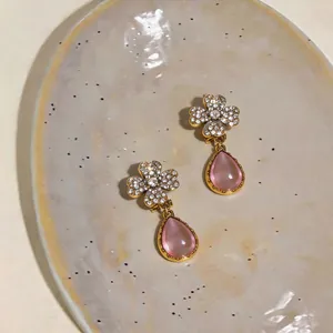 Primo piano di orecchini a fiore vintage con pavé di cristalli e pendenti a goccia rosa