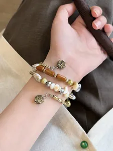 Close-up of vintage Maillard style layered bracelet with beads and flower charms