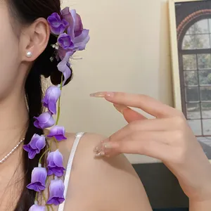 Close-up detail of a purple fabric flower hair clip featuring elegant hanging floral tassels