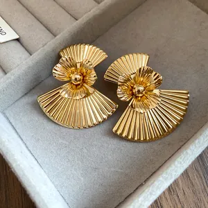 Close-up view of retro gold fan-shaped earrings featuring a pleated floral design