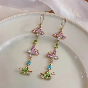 Close-up detail of long tassel butterfly earrings with sparkling colorful zircons