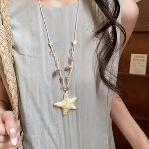 Detalle del colgante de estrella de mar colorida y cuentas de concha en el collar