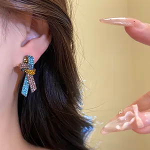 Primer plano de elegantes pendientes de nudo vintage con cristales de colores brillantes