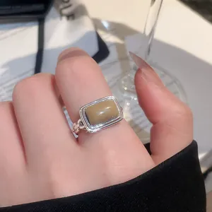 Detailansicht eines vintage geometrischen Rings mit Katzenaugenstein auf dem Finger