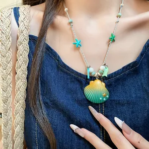 Primer plano de un collar con colgante de concha vibrante y cuentas de estrella de mar.