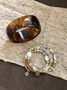 Vintage Maillard resin bangle and multi-strand beaded bracelet set on textured paper