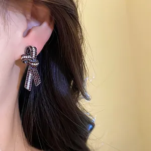 Primer plano de pendientes de lazo vintage con diamantes de imitación rojos y blancos