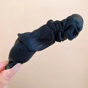 Detailed close-up view of a black pleated fabric banana hair clip showing fine texture