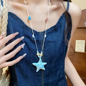 Detalle de un collar con colgante de estrella de mar de colores y cuentas en denim